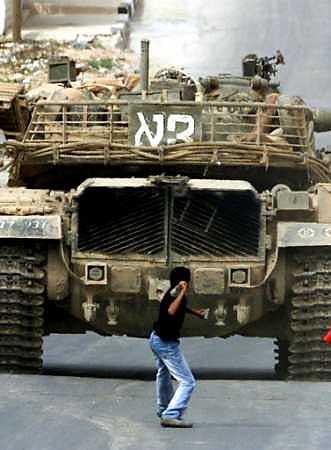 RAMALLAH, A Palestinian boy throws a stone at an Israeli tank.