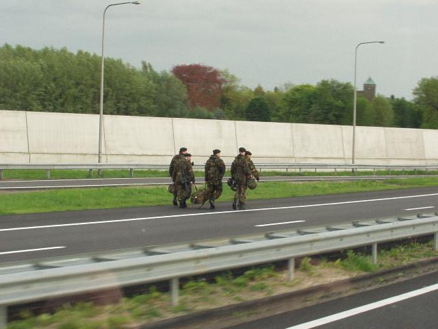 zwaar bewapende militairen op snelweg