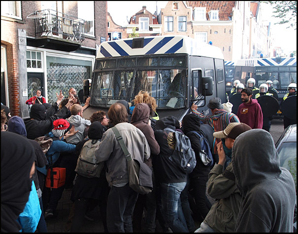 demonstranten houden een politiebusje tegen